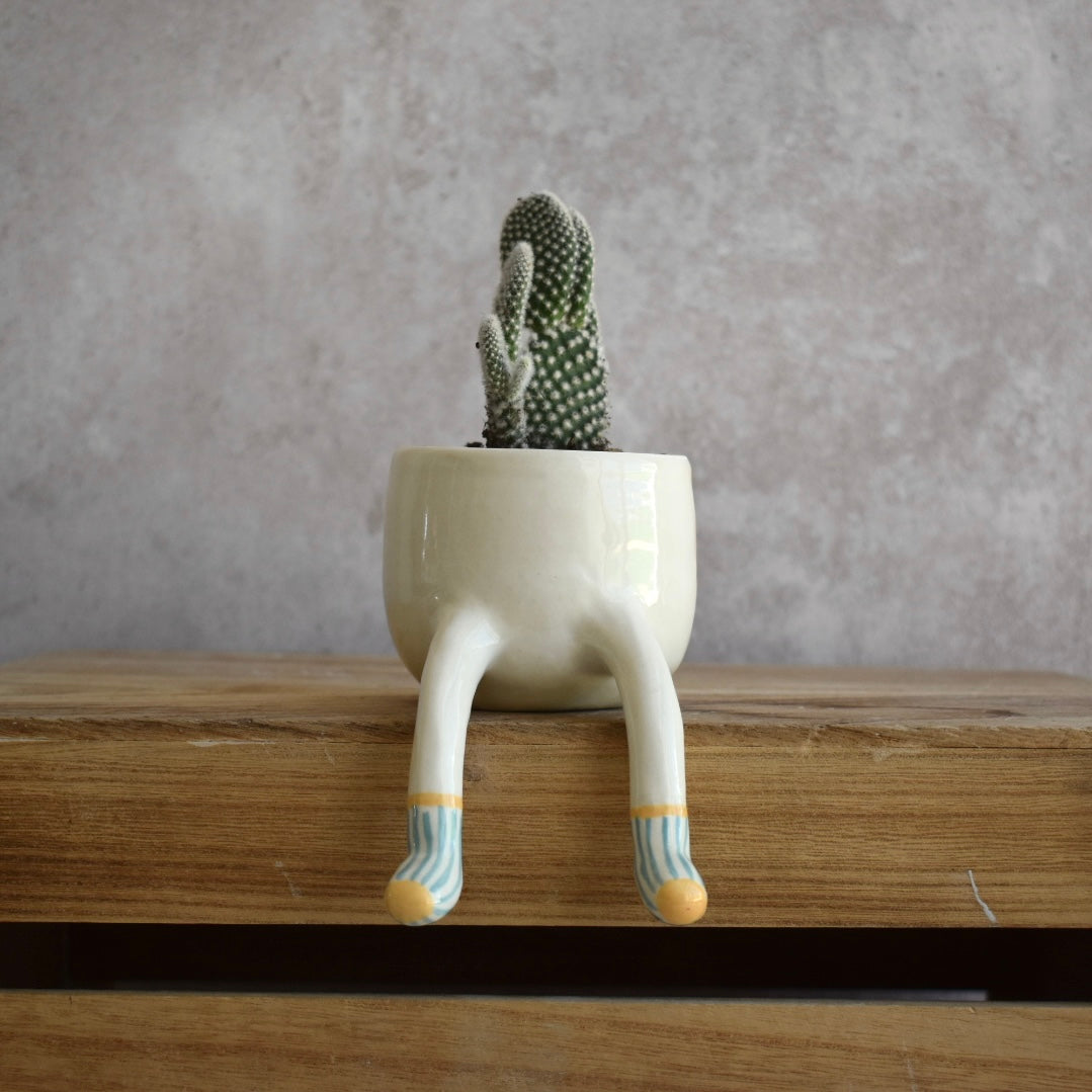 Maceta piernas colgantes calcetines azules chica